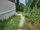 Wooden pathway through overgrown grass leading to a deck and house at 2010 Driftwood Cir, Cumming, GA 30041