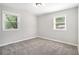 Simple bedroom with gray carpet, neutral walls, and two windows at 2623 Rex Sw Ave, Atlanta, GA 30331