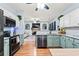 Open concept kitchen boasts granite countertops, stainless steel appliances, and soft green cabinets at 1500 Terminal Ct, Mcdonough, GA 30252