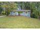 Ranch style home with a blue exterior and well-manicured lawn at 4649 Big Valley Ct, Stone Mountain, GA 30083