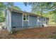 Ranch style home with blue siding and mature trees at 4649 Big Valley Ct, Stone Mountain, GA 30083