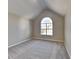 Well-lit bedroom with an arched window and carpeted floors at 12497 Lakeside Pkwy, Fayetteville, GA 30215