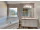 Bathroom boasts a corner bathtub, double vanity, and updated flooring at 12497 Lakeside Pkwy, Fayetteville, GA 30215