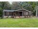 Single-story home with dark brown siding, stone accents, and a covered porch at 116 Southside Dr, Villa Rica, GA 30180