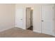 Spacious bedroom with neutral walls and carpet flooring, and access to a bathroom at 188 Sophie Cir, Locust Grove, GA 30248