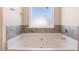 Soaking tub with tile surround and a large window at 188 Sophie Cir, Locust Grove, GA 30248