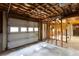 Unfinished basement garage with overhead door and exposed framing at 1210 Lancelot Ct, Loganville, GA 30052