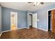 Large bedroom with wood-like tile floors and multiple doors at 8263 Chestnut Dr, Jonesboro, GA 30238