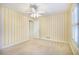 Bright bedroom with yellow and white striped walls and neutral carpet at 1418 Brighton Pl, Loganville, GA 30052