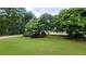 Landscaped yard with green grass and large trees at 2198 Indian Shoals Dr, Loganville, GA 30052