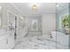 Bright bathroom featuring a freestanding tub and marble flooring at 410 Ward Farm Dr, Powder Springs, GA 30127