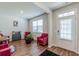 Bright and airy living room with hardwood floors, two red velvet chairs and large windows at 6912 Oak Valley Dr, Douglasville, GA 30134