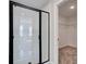 Walk-in shower with white tile and black frame at 261 Dahlia Dr, Woodstock, GA 30188