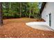 Home's backyard with pine straw, a white retaining wall, and a patio at 2228 Old Dallas Sw Rd, Marietta, GA 30064
