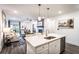 Open concept kitchen with island, stainless steel appliances, and views into living room at 3351 Orwell Way # 2105, Cumming, GA 30041