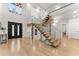 Modern entryway with light oak hardwood floors, floating staircase, and black front door at 2635 Camp Branch Rd, Buford, GA 30519