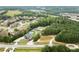 Aerial view of a modern house and lot with surrounding properties and a road in a wooded area at 2635 Camp Branch Rd, Buford, GA 30519
