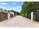 Long driveway with a modern gate and landscaping at 2635 Camp Branch Rd, Buford, GA 30519