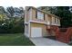 Tan two-story house with red stairs and attached garage at 5300 Forest Downs Ln, Atlanta, GA 30349