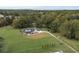 Aerial view showcases expansive property with farmhouse and lush green landscape at 4165 Milford Trl, Cumming, GA 30028