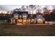 Two story white farmhouse with black metal roof and large yard at dusk at 4165 Milford Trl, Cumming, GA 30028