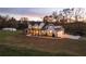 Two story white farmhouse with black metal roof and large yard at dusk at 4165 Milford Trl, Cumming, GA 30028