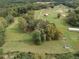 Aerial view showing home, surrounding trees and fields at 4165 Milford Trl, Cumming, GA 30028