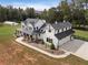 Two story white farmhouse with black metal roof, large yard, and detached garage at 4165 Milford Trl, Cumming, GA 30028