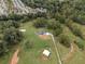 Aerial view shows home nestled on a spacious lot with surrounding trees and neighborhood in background at 4165 Milford Trl, Cumming, GA 30028