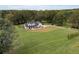 Aerial view of a farmhouse on a large lot with surrounding trees at 4165 Milford Trl, Cumming, GA 30028