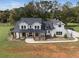 Two story white farmhouse with black roof and large yard at 4165 Milford Trl, Cumming, GA 30028