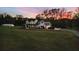Two story white farmhouse with black metal roof and large yard at dusk at 4165 Milford Trl, Cumming, GA 30028