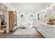 Elegant bathroom with a freestanding tub, double vanity, and herringbone tile floors at 4165 Milford Trl, Cumming, GA 30028