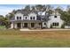 Two-story farmhouse with a covered front porch and landscaped yard at 4165 Milford Trl, Cumming, GA 30028