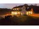 Farmhouse exterior at dusk with attached garage and expansive backyard at 4165 Milford Trl, Cumming, GA 30028