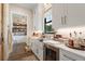 White kitchen with a farmhouse sink, marble countertops, and ample storage at 4165 Milford Trl, Cumming, GA 30028
