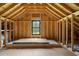 Unfinished attic space with framing and a window at 4165 Milford Trl, Cumming, GA 30028