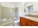 Bathroom with tiled shower, vanity with granite countertop, and neutral-toned tile flooring at 5051 Heather Se Rd, Smyrna, GA 30082
