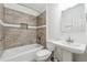 Modern bathroom with tiled shower, pedestal sink, and updated fixtures at 5051 Heather Se Rd, Smyrna, GA 30082