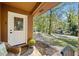 Front porch with white door and decorative glass, wicker seating, and potted mums at 5051 Heather Se Rd, Smyrna, GA 30082
