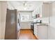 Compact kitchen featuring white cabinetry, stainless steel appliances, and wood-look flooring at 5051 Heather Se Rd, Smyrna, GA 30082