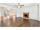 Living room featuring a fireplace, ceiling fan, hardwood floors, and an open view to another room at 5051 Heather Se Rd, Smyrna, GA 30082