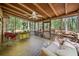 Screened porch with wooden ceiling, outdoor furniture, and wooded backyard views at 5051 Heather Se Rd, Smyrna, GA 30082