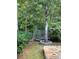 Backyard with trampoline near trees and stone patio at 345 Meadows Ln, Canton, GA 30114