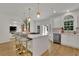 Open concept kitchen with white cabinets, a large island with seating, and gold accents at 3126 Crestmont Nw Way, Kennesaw, GA 30152
