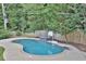 Serene kidney-shaped pool surrounded by lush trees and a wooden fence at 3126 Crestmont Nw Way, Kennesaw, GA 30152