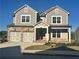 Two-story house with gray siding, stone accents, and a three-car garage at 328 Willow Cv, Canton, GA 30114
