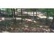 Wooded area with a wooden fence and leaf-covered ground at 1175 Bowerie Chase, Powder Springs, GA 30127