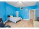Blue bedroom with hardwood floors, a bed, and a ceiling fan at 115 Wilkins Rd, Fayetteville, GA 30214