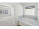 Bright bathroom with a soaking tub and view into bedroom at 11834 Rizvan Pl, Covington, GA 30014